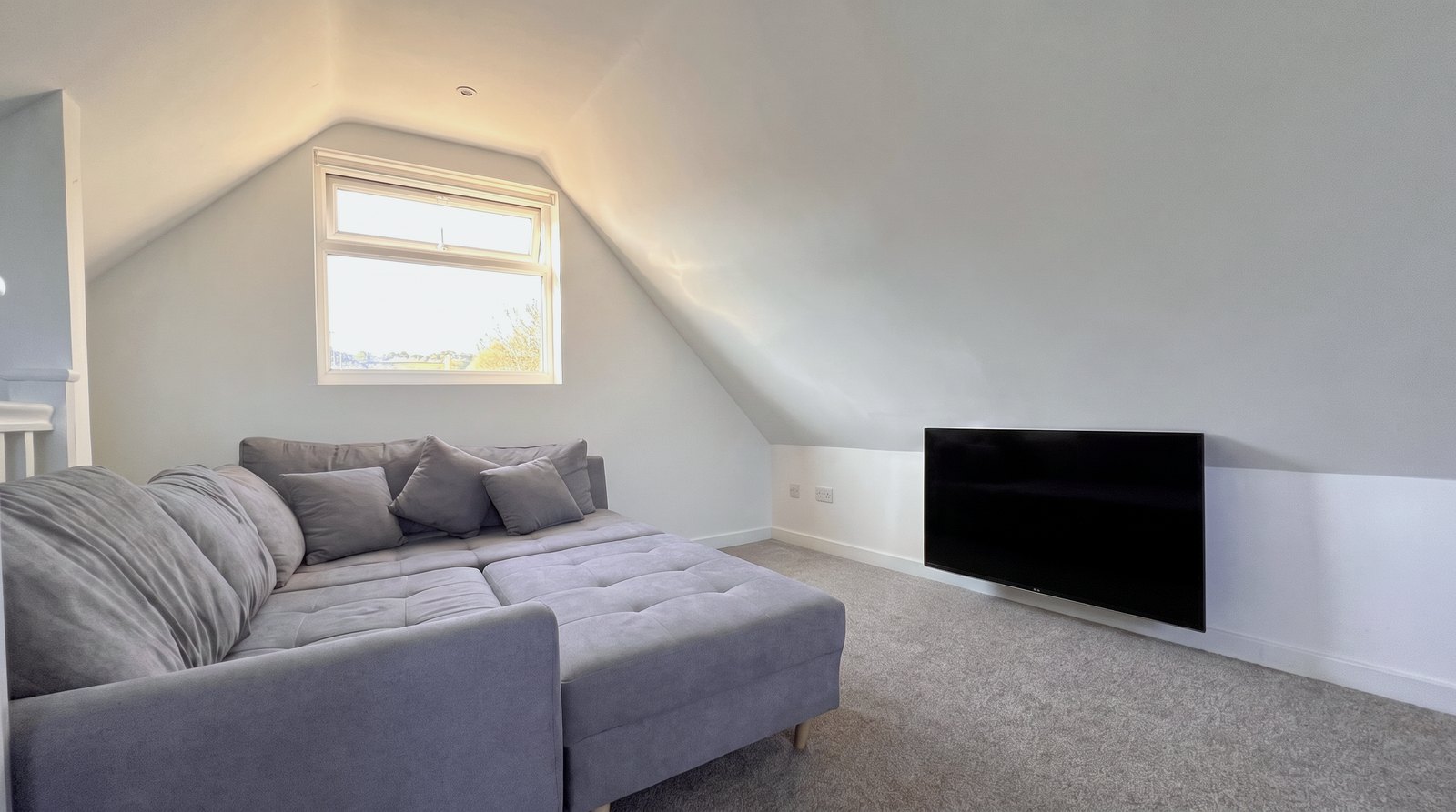 Corner sofa and television in the studio apartment seating area.